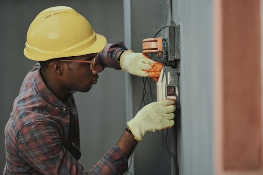 A technician inspects an electrical panel.
